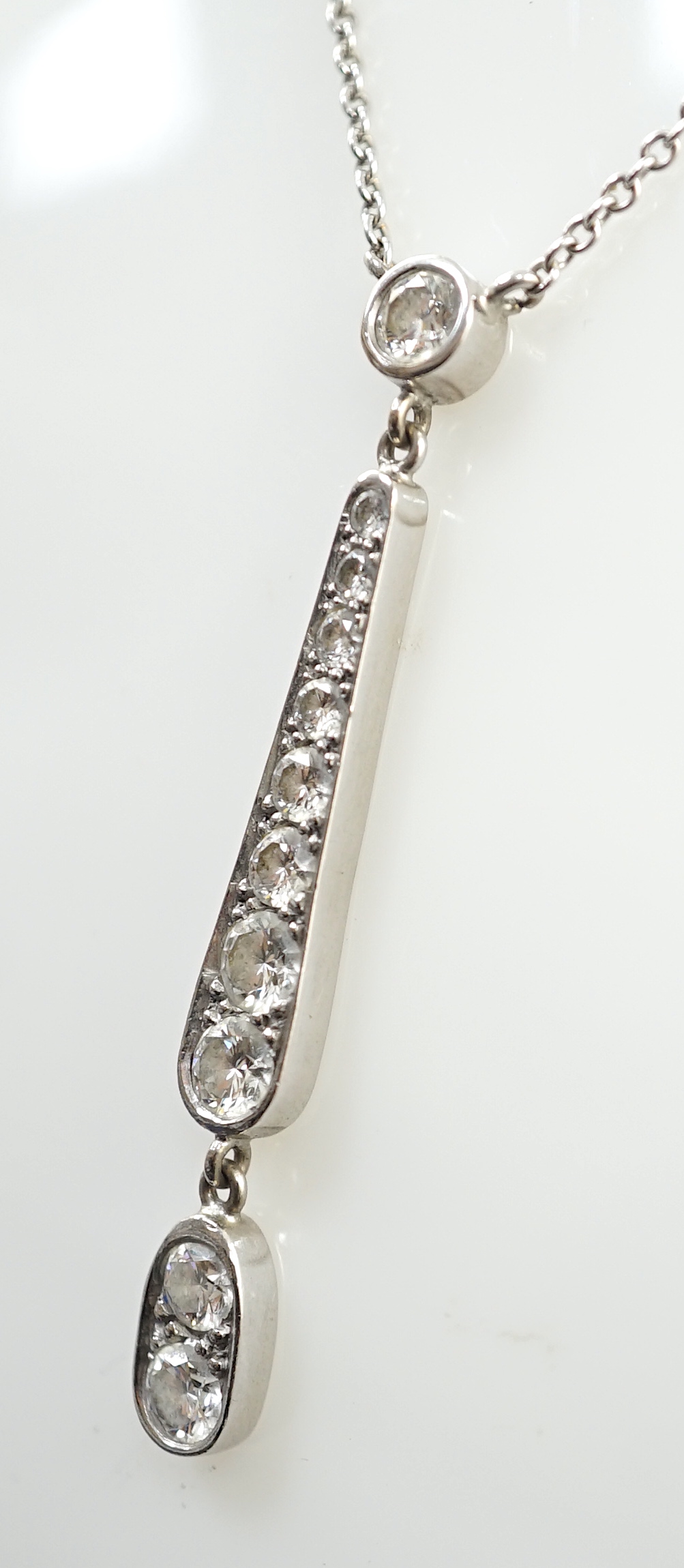 A modern 18ct white gold and graduated eleven stone diamond set drop pendant necklace